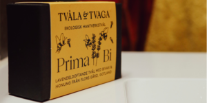 Rektangulär tvålförpackning med gul etikett och texten Tvåla & Tvaga, ekologisk hantverkstvål, Prima Bi samt lavendeldoftande tvål med bivax och honung från Flors gård, Gotland