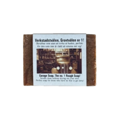 Handgjord Verkstadstvål med grov skrubb, fotograferad framifrån i rustik garagekänsla med tydlig etikett och rå struktur som signalerar effektiv rengöring för smutsiga händer